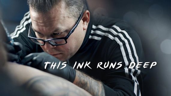 a tattoo artist tattooing on a client