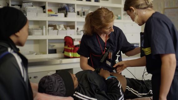 Woman in scrubs examining patient
