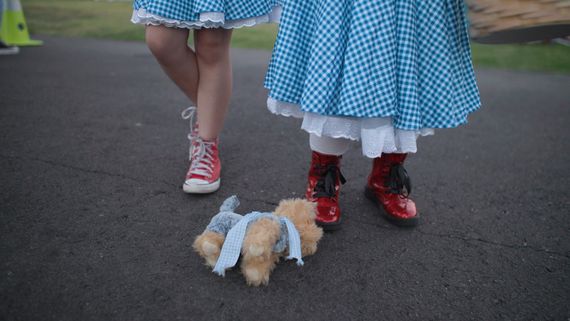Legs of two people in gingham and red shoes