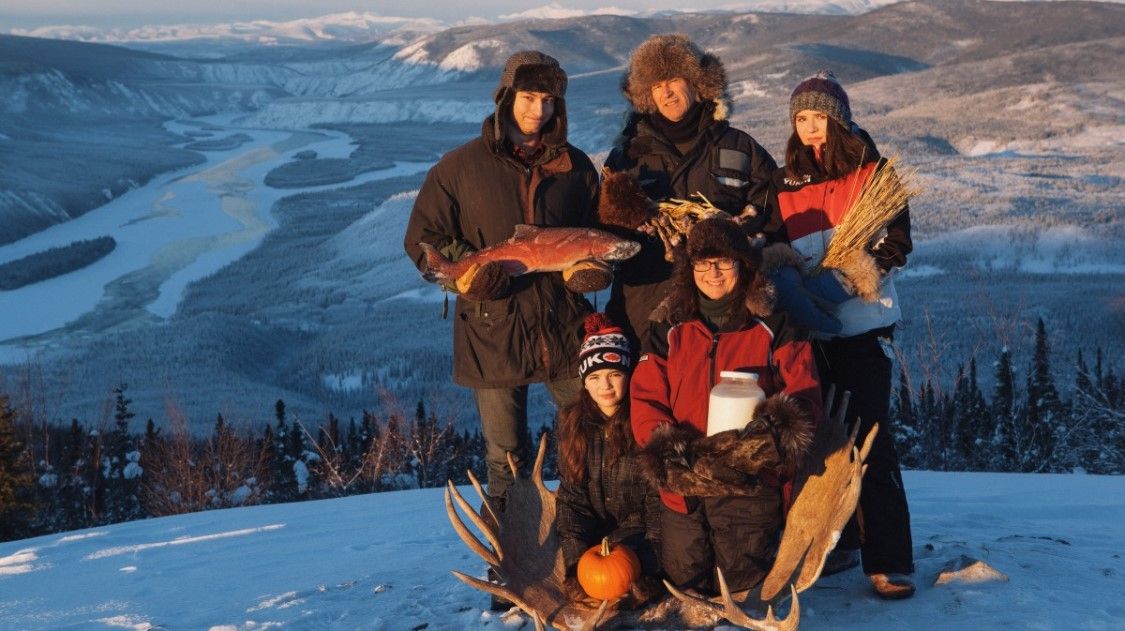 a group of people standing with food on a mountain