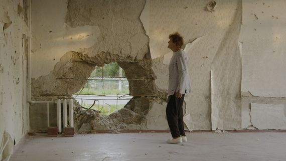 Woman in room with large hole in wall