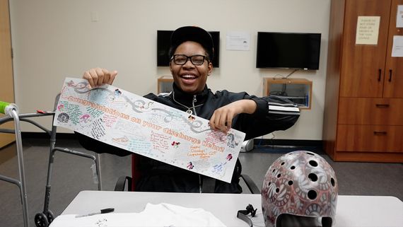 Black teen holding congratulations card