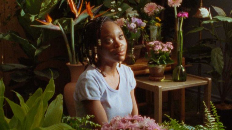 Black girl sitting among flowers