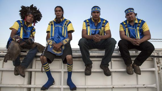 four men sitting on a ledge