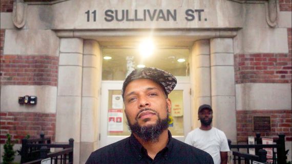 a man standing in front of a building marked 11 sullivan st.