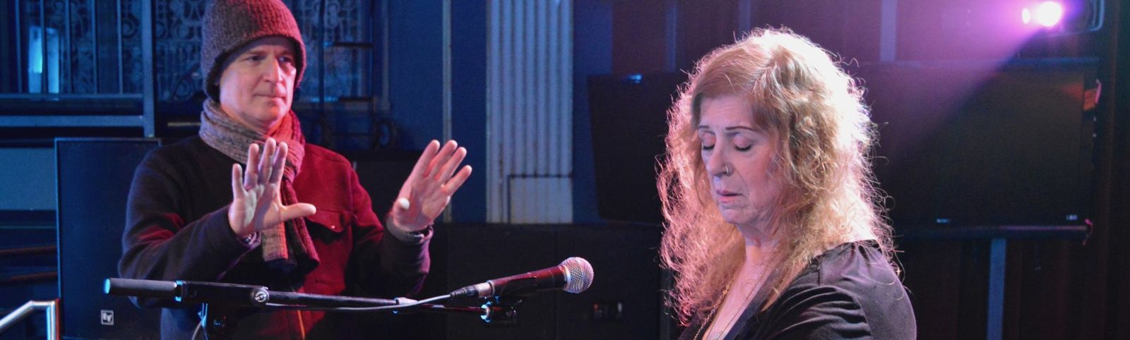 Man coaching woman at microphone