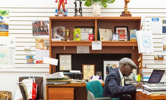 a man sitting at a desk full of books and papers