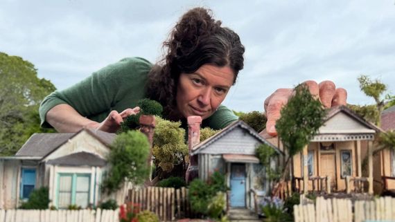 a woman creating miniature houses and trees