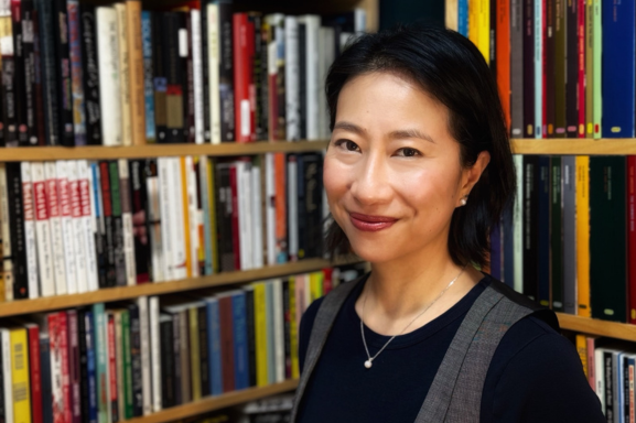 Heidi Tao Yang standing in front of bookshelves