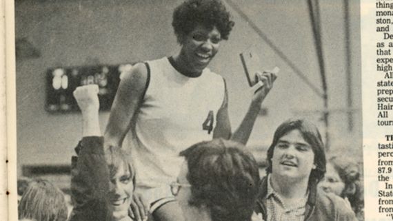 a black and white image of a womans basketball team with a player lifted on their shoulders