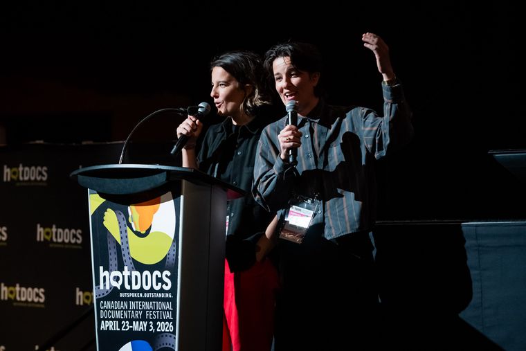 Two pitch team members with mics on stage