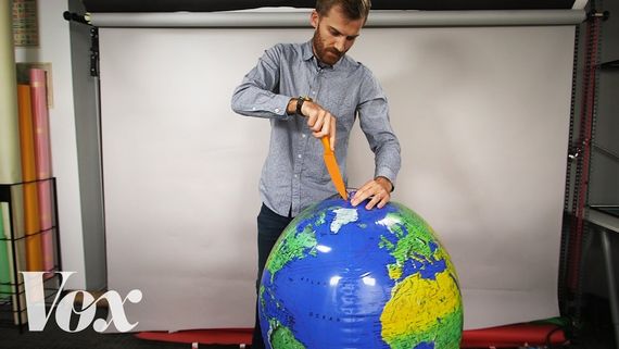 someone cutting into a giant globe