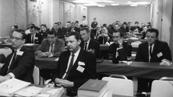 a large group of men in suits sitting at tables