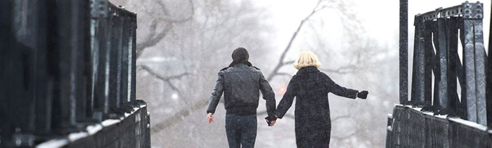 a couple holding hands on a bridge