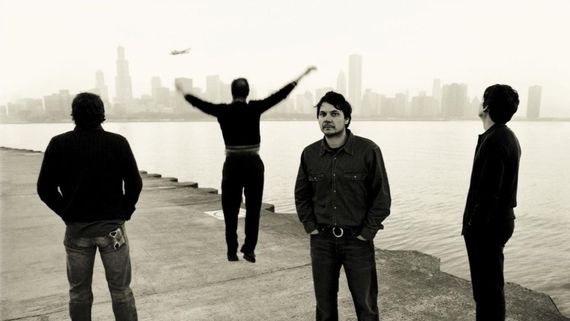 four men standing together along a waterfront