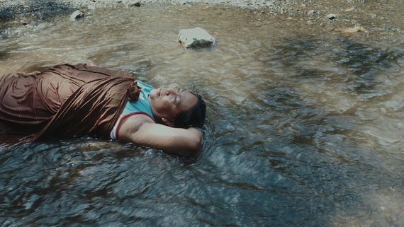 Person laying in a shallow river