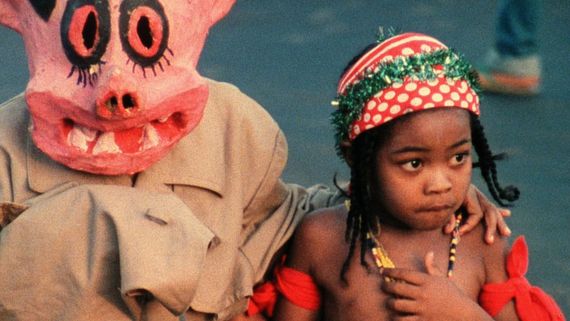 a person in a pink costume next to a child with a hat