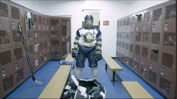 a hockey player standing alone in the change room