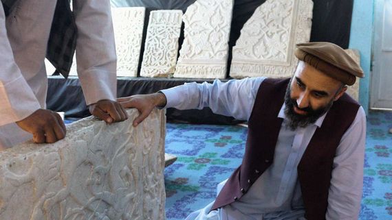 two men looking at an artifact