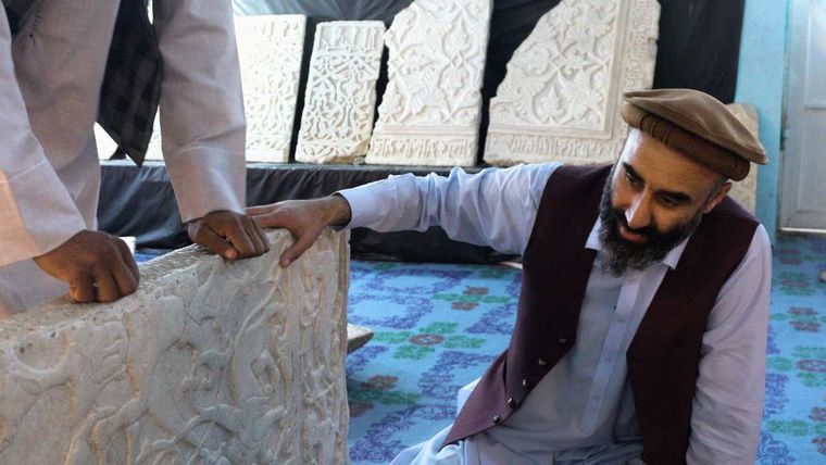 two men looking at an artifact