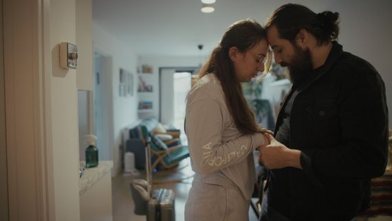 Man and woman standing with foreheads together